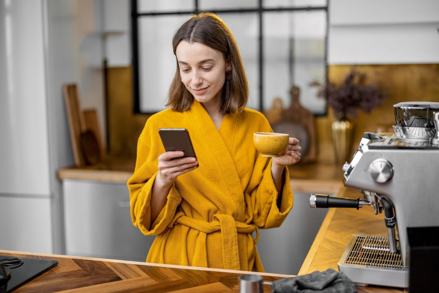 Woman standing in clean kitchen on her phone